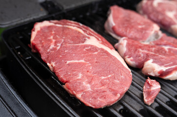 Juicy raw steaks on grill for perfect barbecue cooking