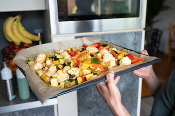 Freshly baked tray of colorful roasted vegetables in modern kitchen