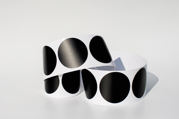 Bold black and white polka dot paper bracelets against a light background