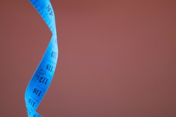 Blue measuring tape isolated on brown background. diet for weight loss concept. 