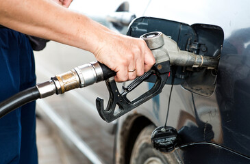 Gas station. A gas station attendant in a car's fuel tank. A man refuels a car with gasoline....