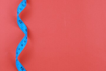 Blue measuring tape isolated on red background. diet for weight loss concept. With copy space