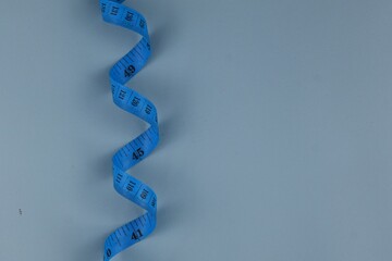 Blue measuring tape isolated on blue background. diet for weight loss concept.