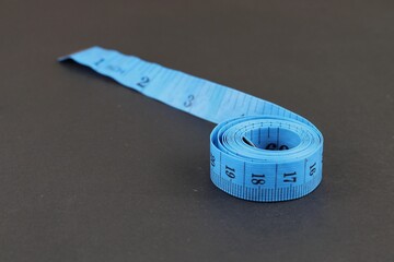 Blue measuring tape isolated on black background. diet for weight loss concept.