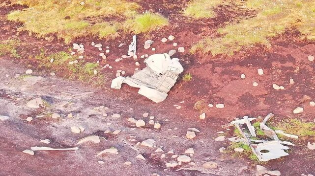 Drone view of scattered wreckage debris of the B-29 Superfortress WWII plane, on moorland terrain in the Peak District, England.