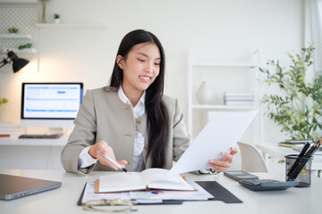Smiling businessman holding paperwork and checking details for a business project.