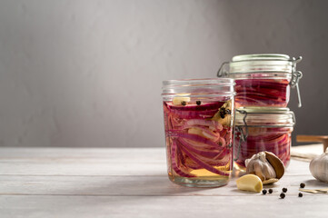Cooking homemade pickled red onions in jars, bright background, copy space