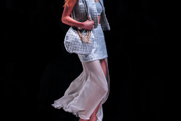 Woman wearing tweed blue jacket and skirt, classic fashion clothing on black background