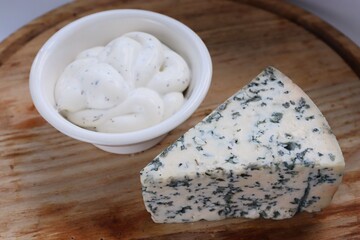 Creamy Dorblu Sauce and Cheese Wedge on Wooden Board as an Aesthetic Accent for Gourmet Recipes and Premium Food Content