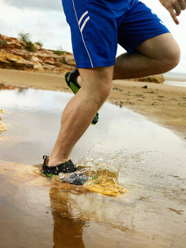 Running through a puddle and splashing at the beach