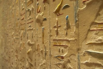 Close up of colorful hieroglyphics in the tomb of a Pharaoh, in the Valley of the Kings, Luxor, Egypt. Perspective view with selective focus.