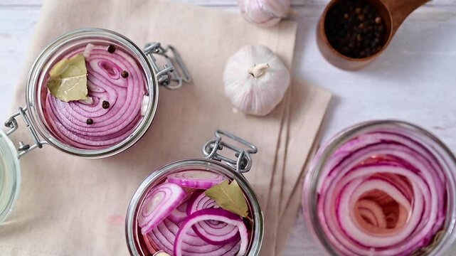 Homemade pickled red onions in jars, bright background, top view