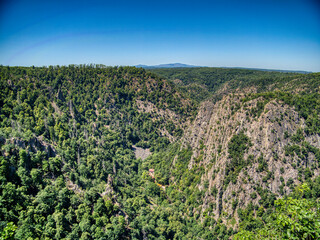A panoramic view of the lush green Bode Valley in the Harz Mountains, Germany. Rugged cliffs and...