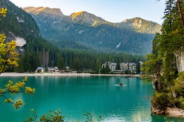 Idyllic view of Lago di Braies in South Tyrol, Italy. A tranquil path follows the shore, surrounded by towering pines and the grandeur of the Dolomite peaks. Pure natural beauty.
