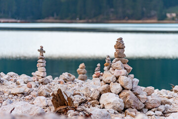 Artful stone cairns standing tall by tranquil waters. Representing stability, balance, and human...