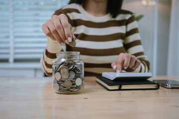 A woman holds a piggy bank, which symbolizes savings, financial planning, and economic challenges....