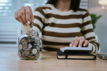 A woman holds a piggy bank, which symbolizes savings, financial planning, and economic challenges....