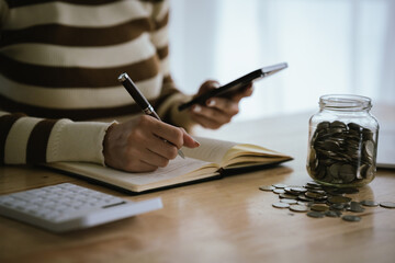 A woman holds a piggy bank, which symbolizes savings, financial planning, and economic challenges....