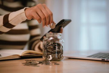 A woman holds a piggy bank, which symbolizes savings, financial planning, and economic challenges....