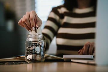 A woman holds a piggy bank, which symbolizes savings, financial planning, and economic challenges....