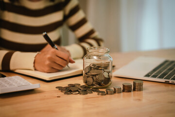 A woman holds a piggy bank, which symbolizes savings, financial planning, and economic challenges....