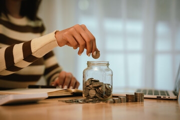 A woman holds a piggy bank, which symbolizes savings, financial planning, and economic challenges....