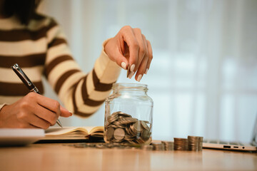 A woman holds a piggy bank, which symbolizes savings, financial planning, and economic challenges....
