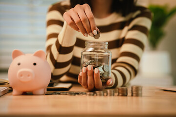 A woman holds a piggy bank, which symbolizes savings, financial planning, and economic challenges....