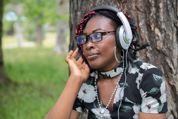 Black Woman Listening Audio Content with Headphones Outdoors