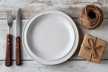 A place setting with a white plate fork knife and a wrapped present box