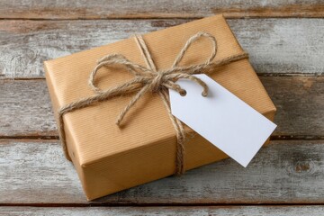 A brown paper wrapped gift with twine and a blank tag on wood surface