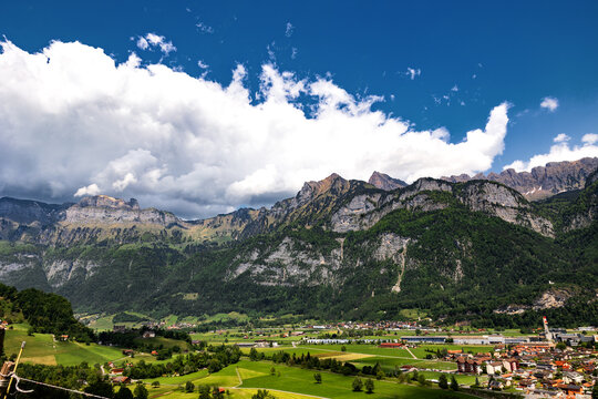 Switzerland, Swiss Alps, Canton St. Gallen, Fr&uuml;msel mountains, town of Flums in the valley, summer 2025. Sunny day with clouds, mountain range. Hiking, tourism, travel destination, recreation.