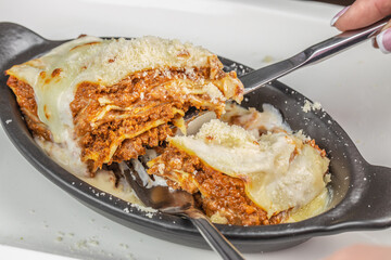 A hearty serving of classic Italian lasagna with layers of rich meat sauce, creamy bechamel, and...