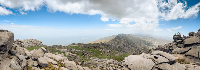 Panoramic View of Rugged Mountain Range with Distant Hikers