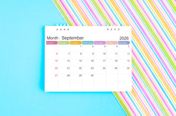 September 2026 desk calendar on blue and rainbow color background.