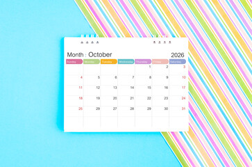 October 2026 desk calendar on blue and rainbow color background.