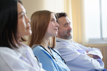 Multiracial medical team listening closely to a medical intern presentation or report, ready to...