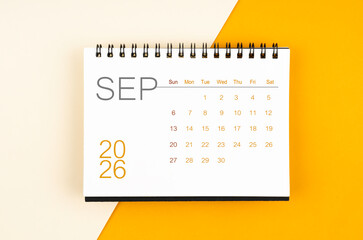 Desk calendar for September 2026 year on yellow color background, Flat lay.