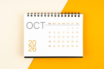 Desk calendar for October 2026 year on yellow color background, Flat lay.