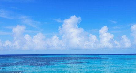Obraz premium Serene Ocean Vista: Cumulus Clouds Over Turquoise Waters