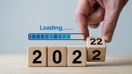 Hand turning wooden cubes displaying year twenty two image