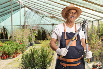 Smiling gardener holding a fence cutter