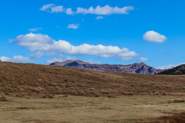 Volcanic Landscape with Smoke Rising from Mount Aso under Blue Sky in Japan
