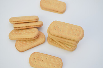 Stack of sandwich cookies on a white surface.