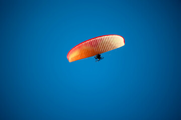 Ein Paragleiter mit Motorantrieb am Himmel.