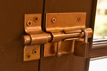 Detailed view of a sliding latch lock on a rustic door—evoking traditional hardware and secure...