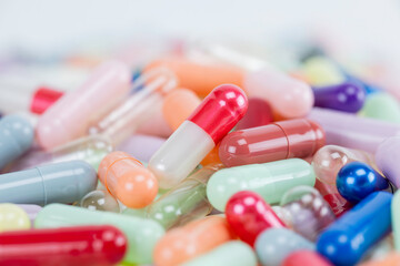 A macro shot of a colorful pile of medicine pills and capsules with a shallow depth of field. A pharmacy or healthcare background.
