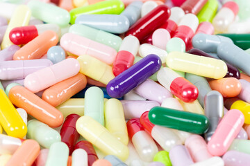 A background of many colorful pills and capsules. A concept for the pharmacy, healthcare, and...