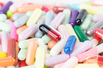 A macro shot of a pile of colorful medicine pills and capsules. A pharmacy or pharmaceutical industry background.