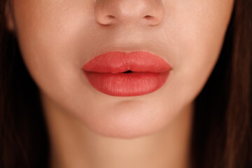 Closeup of symmetrical, full lips after enhancement with pink pigment and smooth finish.